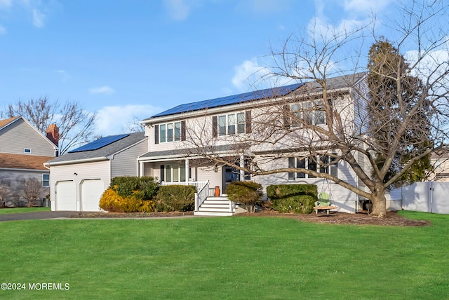 view of front of home with covered porch, solar panels, a front lawn, and a garage