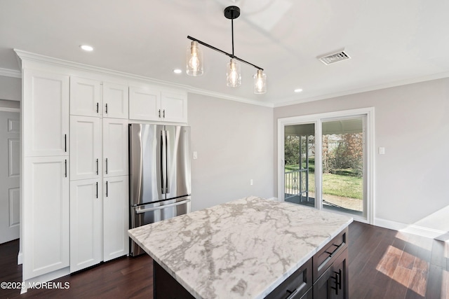 kitchen featuring visible vents, freestanding refrigerator, dark wood-style flooring, crown molding, and light stone countertops