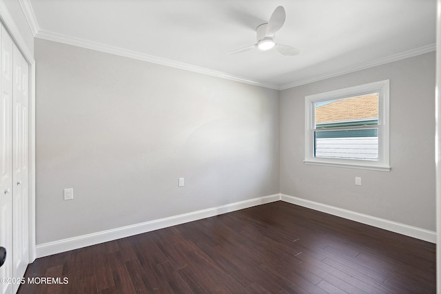 empty room featuring baseboards, ceiling fan, ornamental molding, and dark wood-style flooring