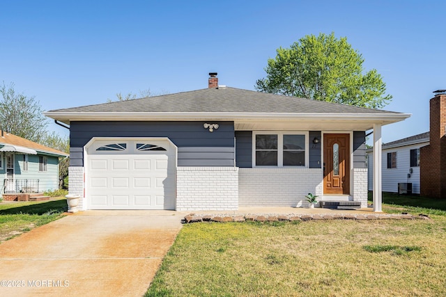 view of front of property with an attached garage, a front lawn, driveway, and brick siding