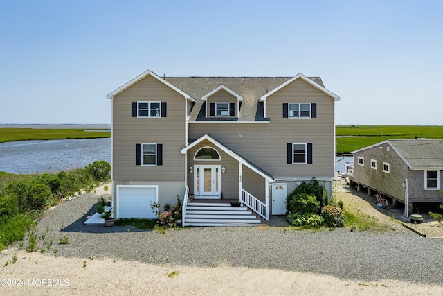 view of front of property with a garage and a water view