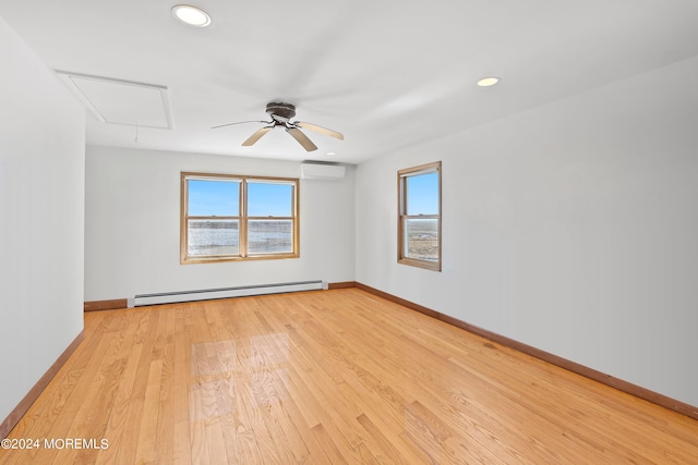 unfurnished room featuring a baseboard radiator, a wall unit AC, ceiling fan, and light hardwood / wood-style flooring