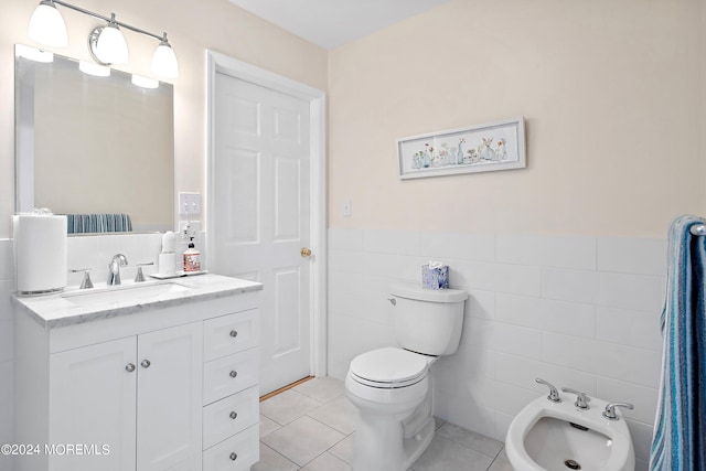 bathroom featuring tile walls, a bidet, toilet, tile floors, and large vanity