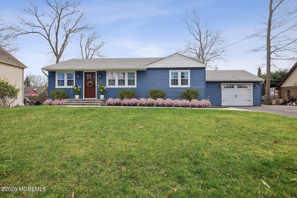 single story home featuring a garage and a front yard