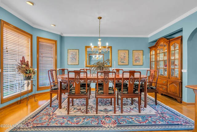 dining space featuring an inviting chandelier, crown molding, and light hardwood / wood-style floors