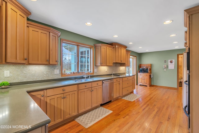 kitchen with backsplash, sink, dishwasher, and light hardwood / wood-style floors