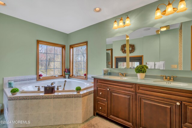 bathroom featuring vanity and tiled tub