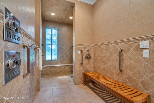 bathroom featuring a tile shower, tile patterned floors, and tile walls