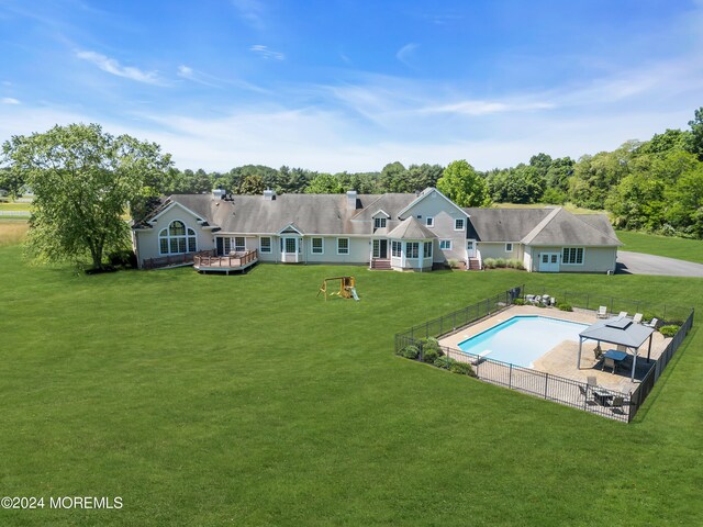 back of property with a patio area, a lawn, and a fenced in pool