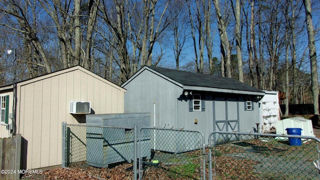 exterior space with an AC wall unit and an outdoor structure