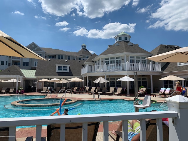 view of swimming pool featuring a patio area and a hot tub