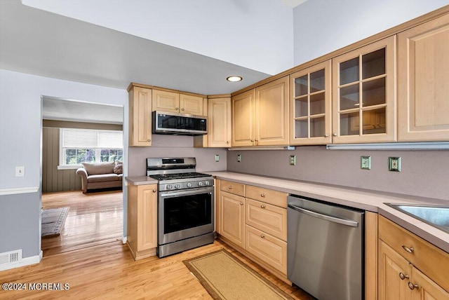 kitchen with light brown cabinetry, light hardwood / wood-style flooring, and appliances with stainless steel finishes