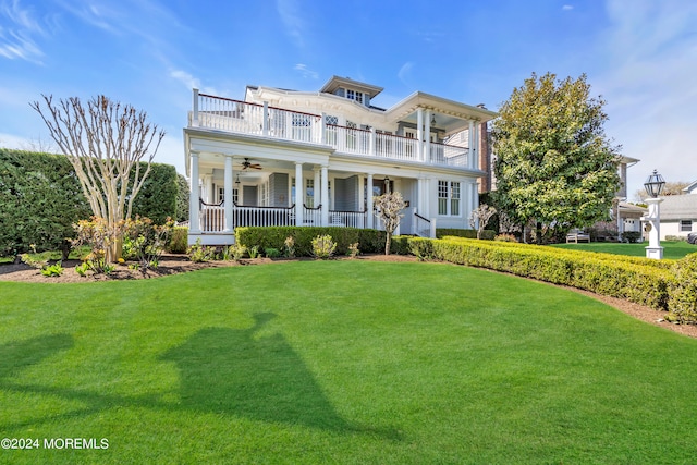 view of front facade featuring ceiling fan, a porch, a balcony, and a front yard