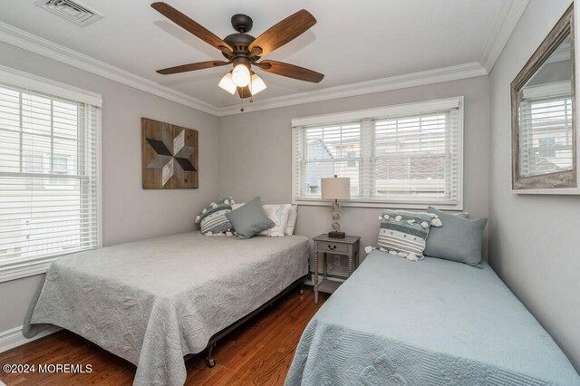 bedroom featuring dark wood-style floors, visible vents, and ornamental molding