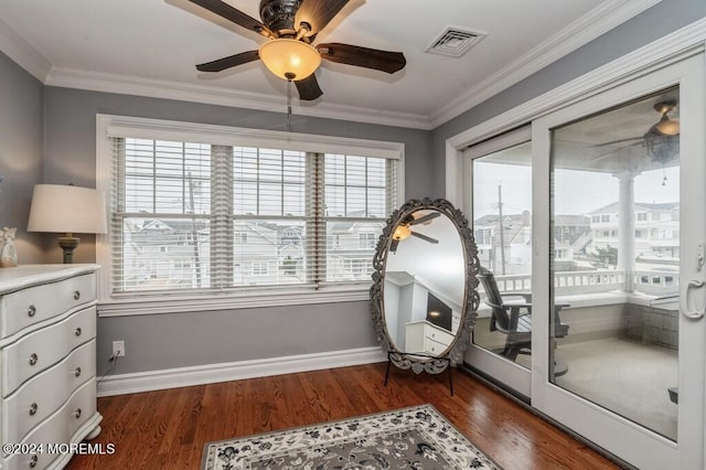 living area with wood finished floors, visible vents, plenty of natural light, and ornamental molding