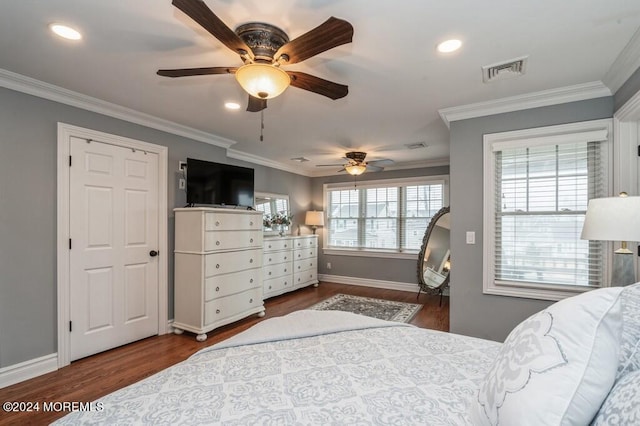 bedroom with crown molding, wood finished floors, baseboards, and visible vents