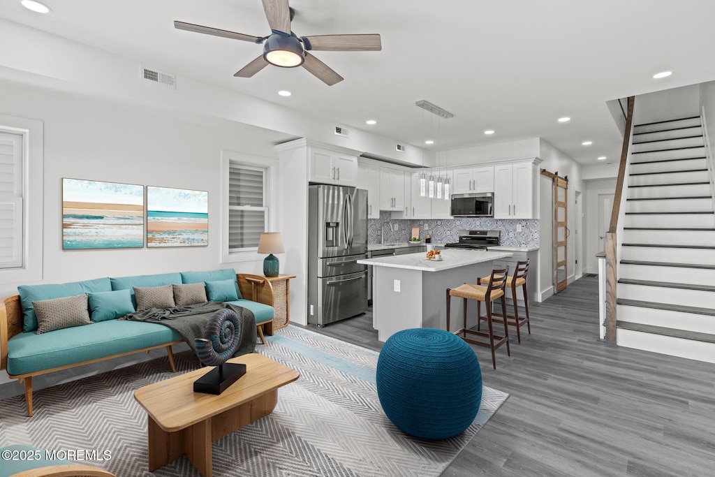 living room featuring ceiling fan and light wood-type flooring