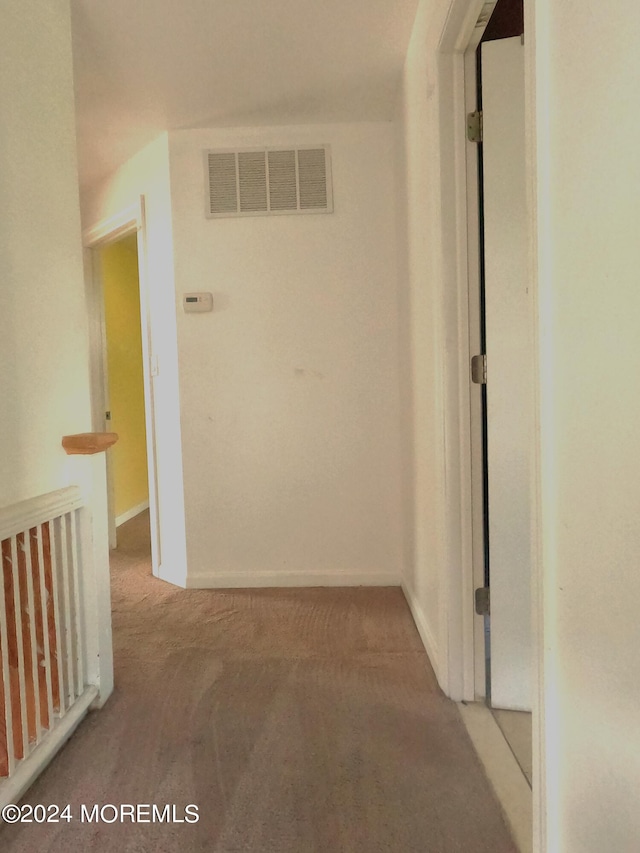 hallway featuring light colored carpet