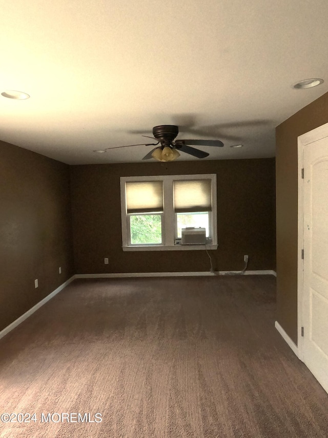 unfurnished room with ceiling fan and dark carpet