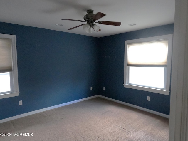 unfurnished room featuring ceiling fan, carpet, and a wealth of natural light