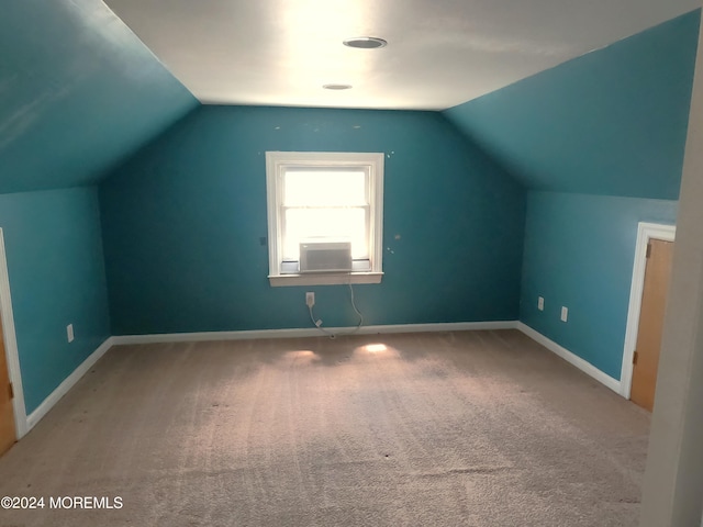 additional living space featuring vaulted ceiling and carpet flooring