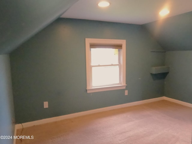 additional living space with vaulted ceiling and carpet