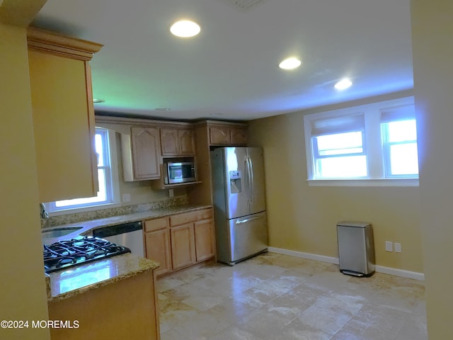 kitchen featuring light brown cabinets, light tile patterned flooring, stainless steel appliances, and sink