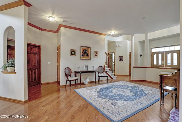 foyer featuring wood-type flooring and crown molding