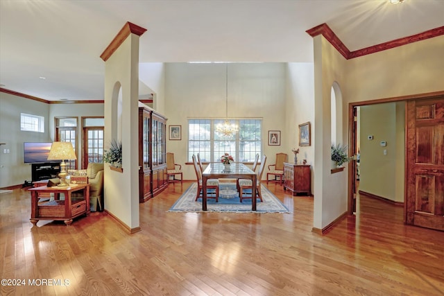 dining room with plenty of natural light, hardwood / wood-style floors, and a high ceiling