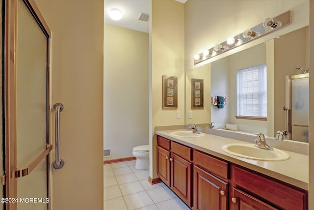 bathroom featuring oversized vanity, tile floors, toilet, and double sink