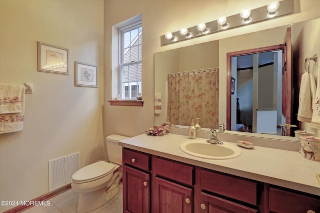 bathroom featuring vanity with extensive cabinet space, toilet, and tile floors