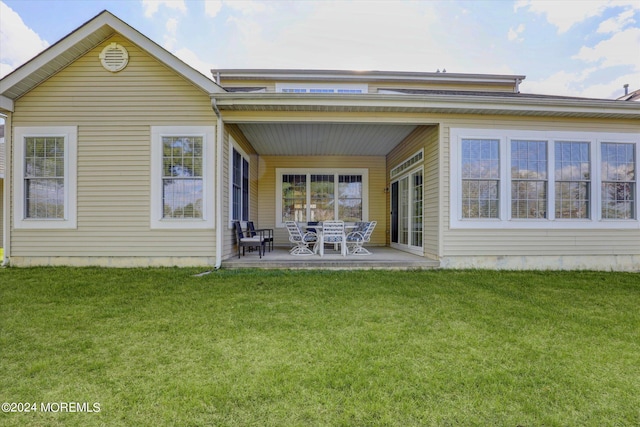 rear view of property with a lawn