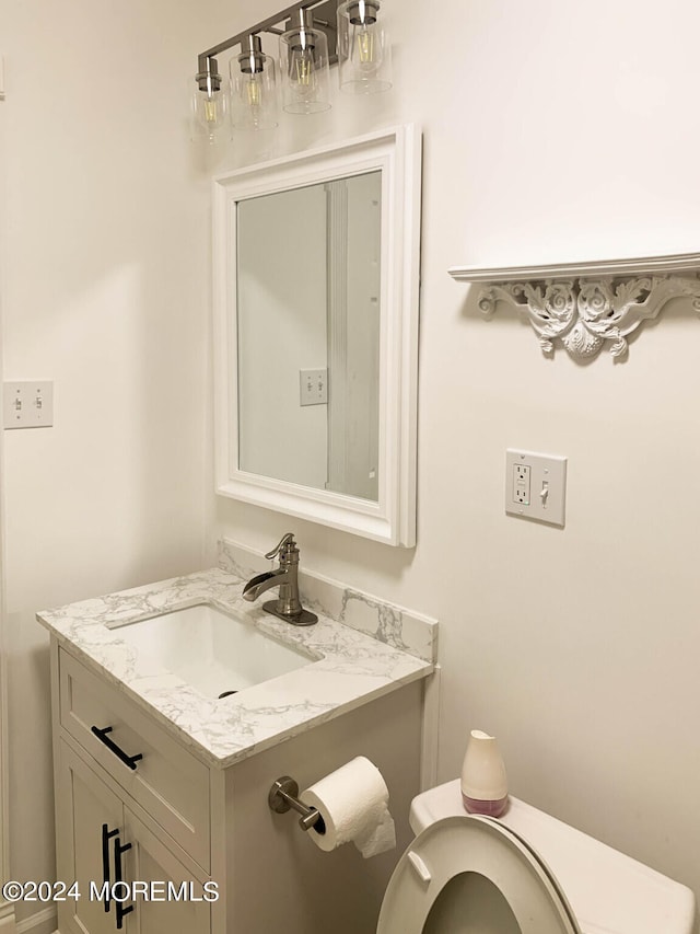 bathroom featuring oversized vanity and toilet