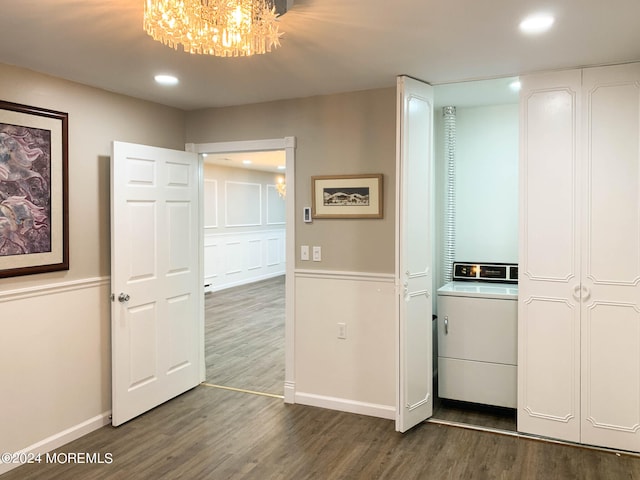 unfurnished bedroom featuring a chandelier, dark wood-type flooring, and washer / clothes dryer