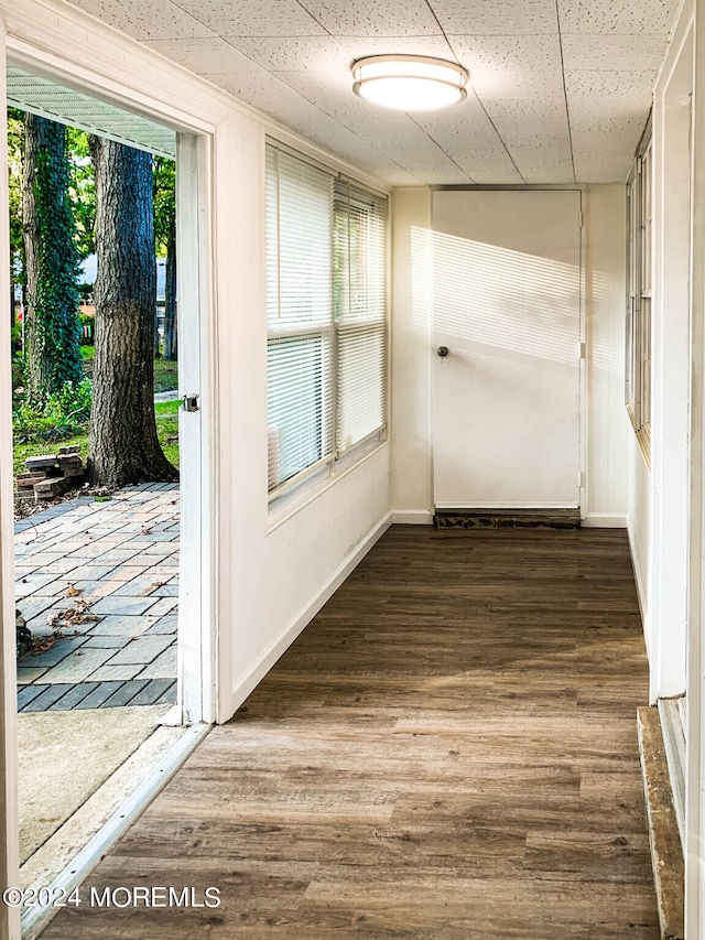 hallway featuring hardwood / wood-style flooring and a paneled ceiling