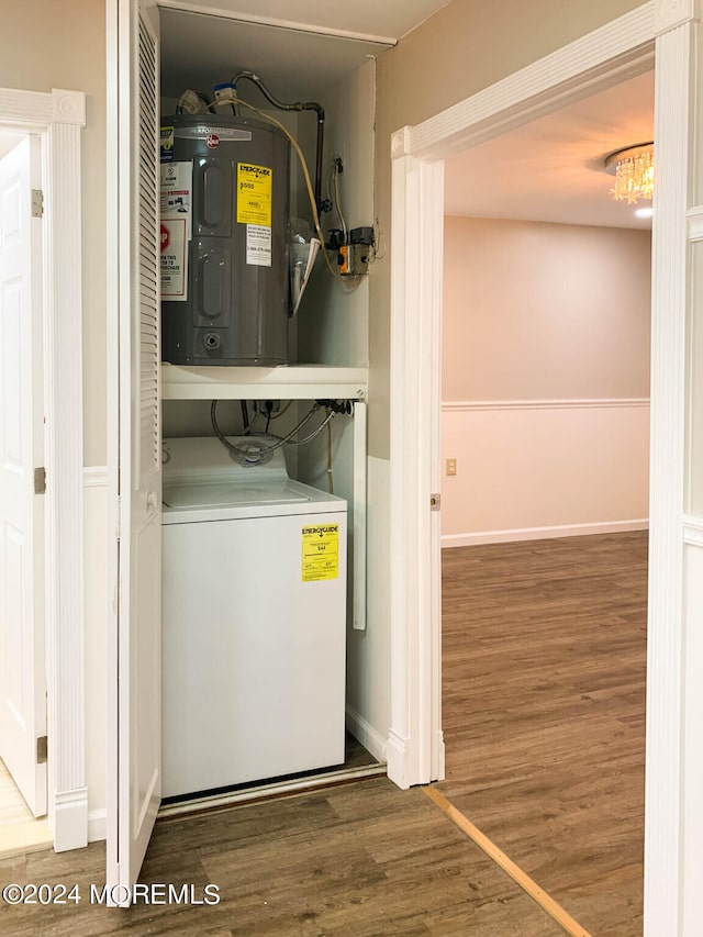 clothes washing area featuring hardwood / wood-style floors, washer / clothes dryer, and electric water heater