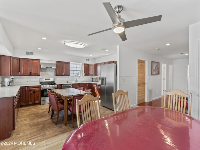 dining space with ceiling fan, sink, and light wood-type flooring