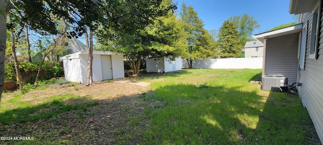 view of yard featuring central AC unit and a shed