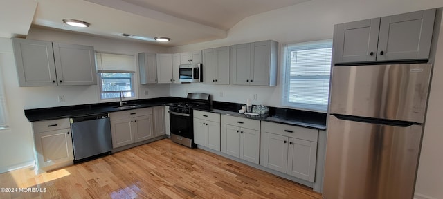 kitchen featuring gray cabinetry, appliances with stainless steel finishes, sink, and light hardwood / wood-style floors