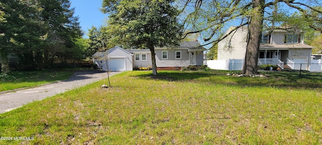 view of front of home with a garage, a front yard, covered porch, and an outdoor structure