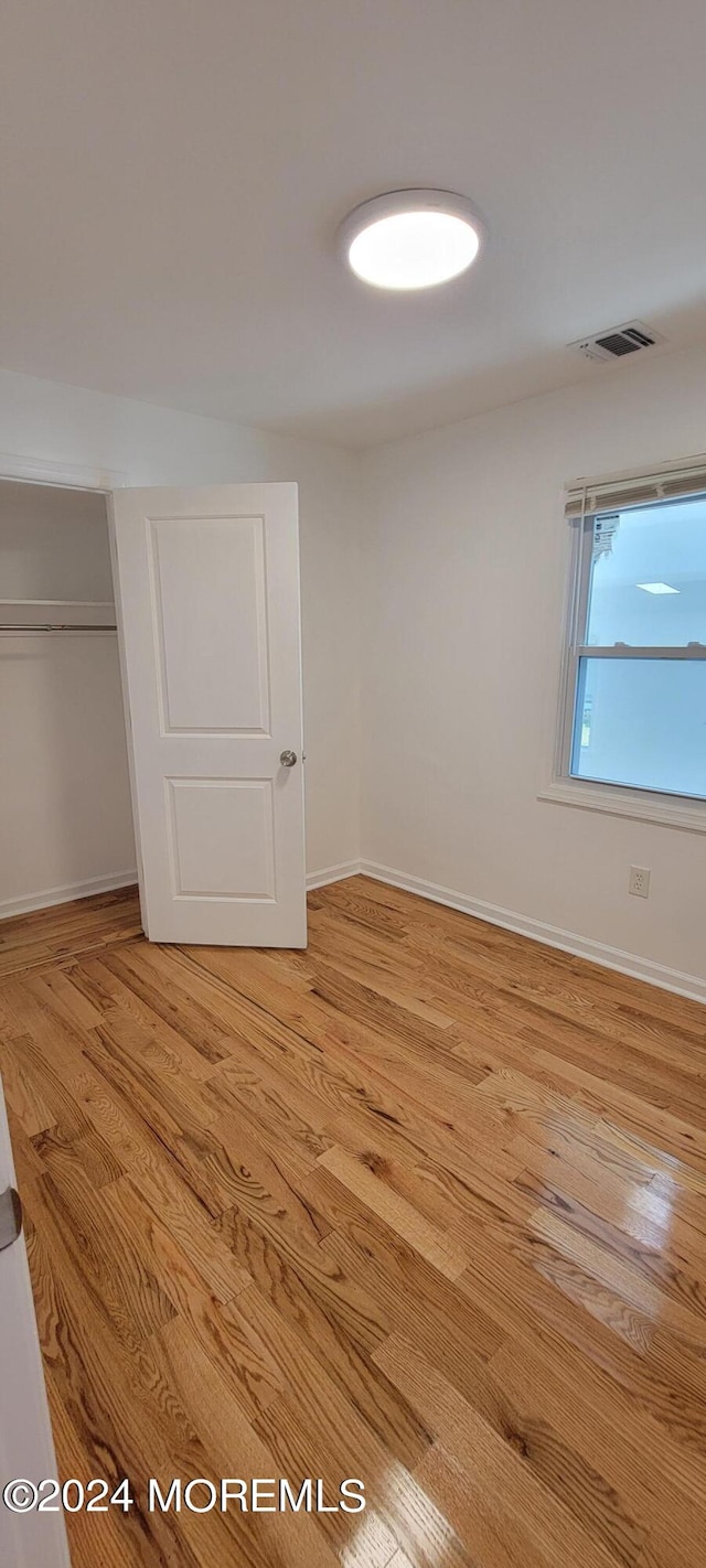 unfurnished bedroom featuring light hardwood / wood-style floors and a closet