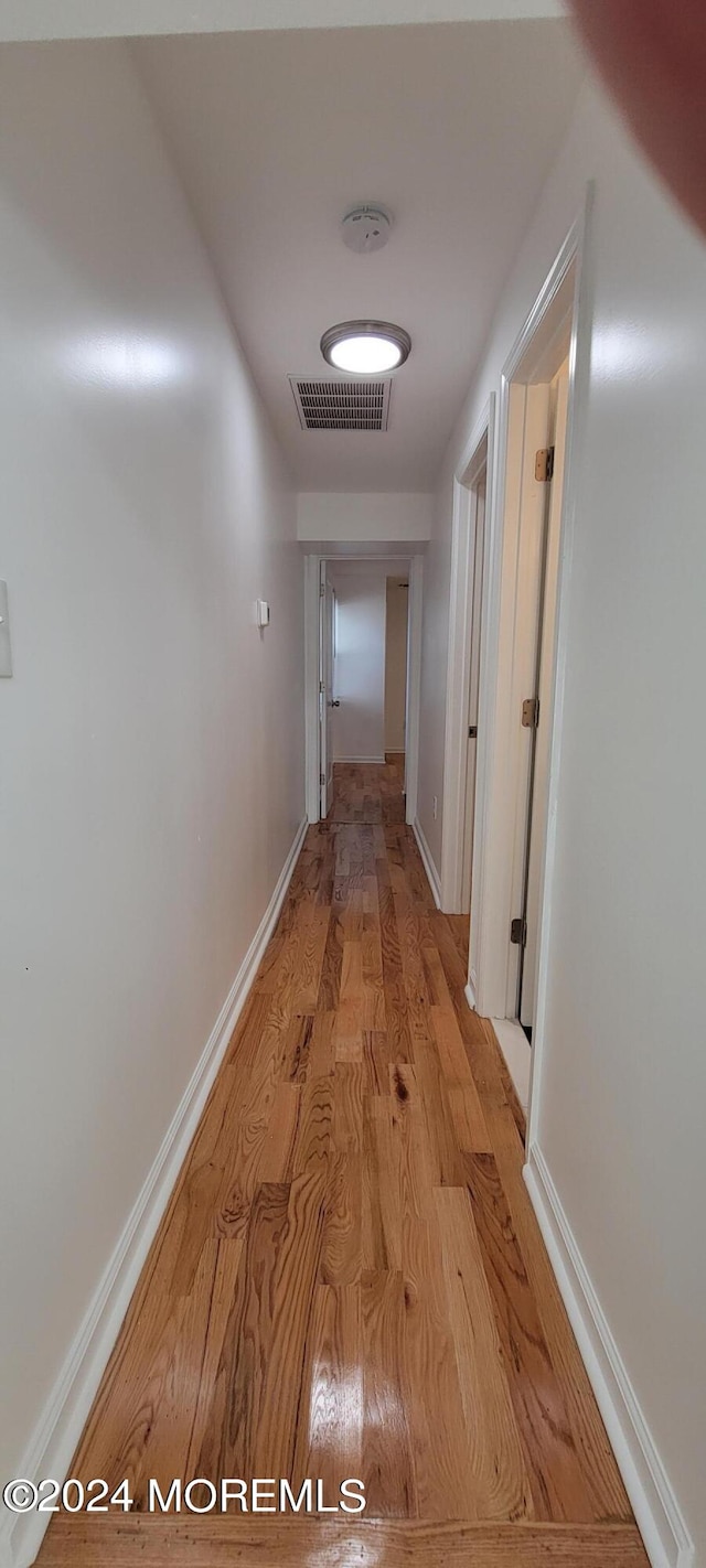 hallway with light hardwood / wood-style floors