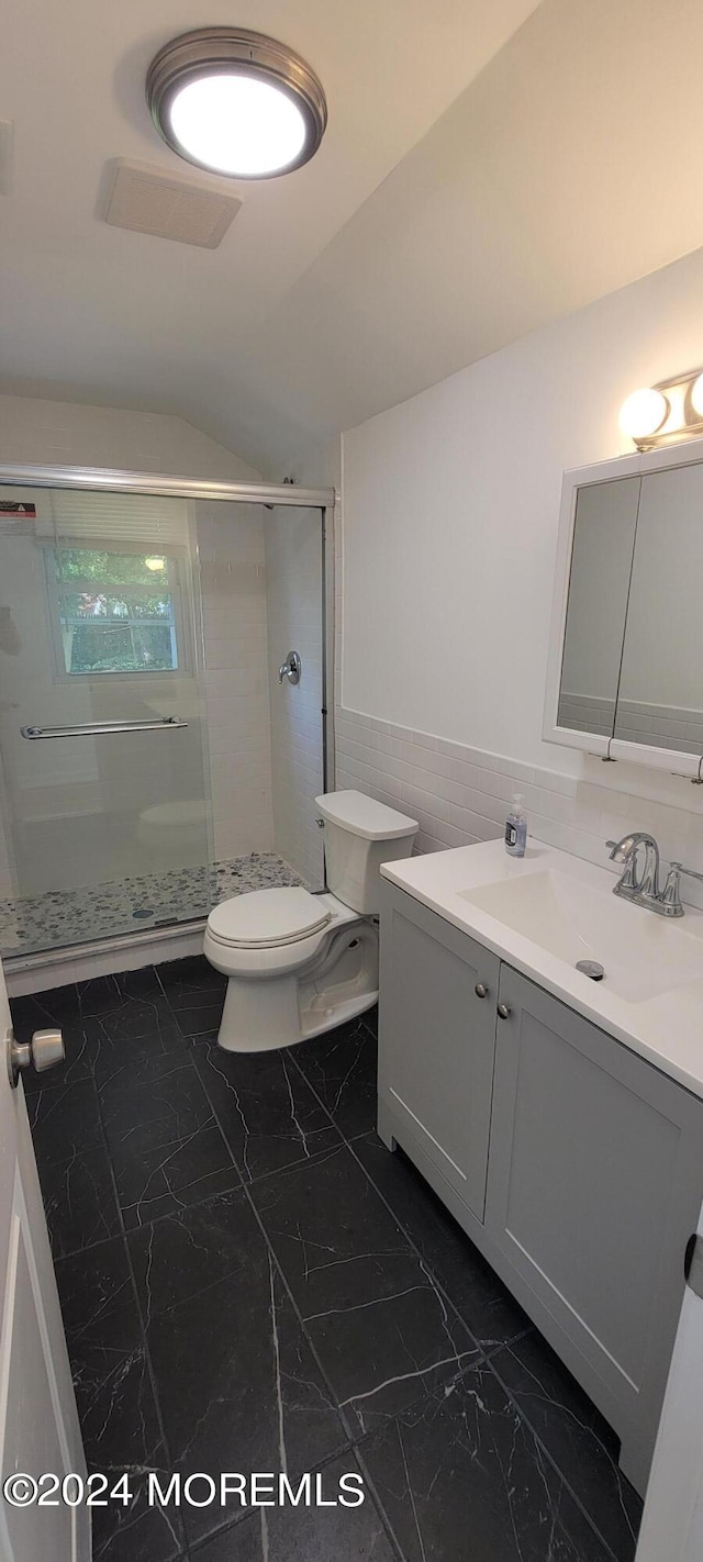 bathroom with vanity with extensive cabinet space, an enclosed shower, tile floors, lofted ceiling, and toilet