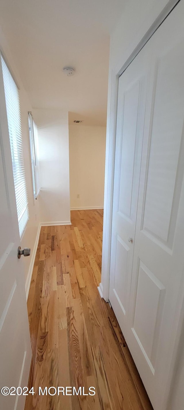 corridor with light hardwood / wood-style flooring