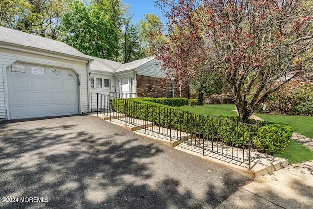 ranch-style house featuring aphalt driveway, brick siding, a garage, and a front yard