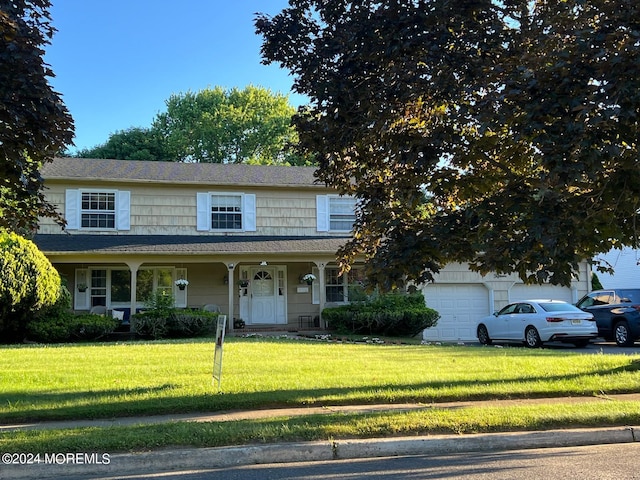 view of front of house featuring a garage, a front lawn, and a porch