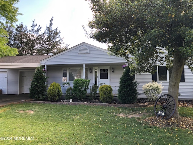 view of front of house with a porch, a garage, and a front lawn