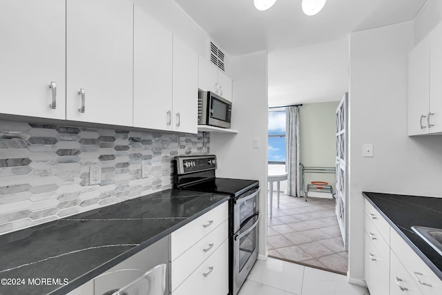 kitchen featuring tasteful backsplash, white cabinetry, sink, dark stone countertops, and stainless steel appliances