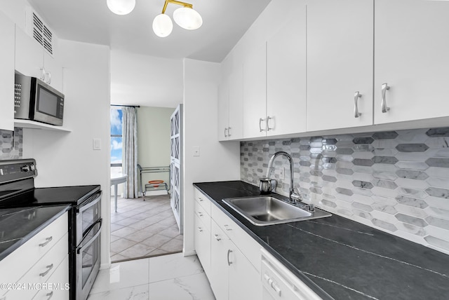 kitchen with white cabinetry, stainless steel appliances, sink, and tasteful backsplash