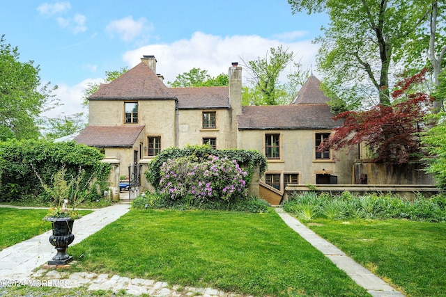 back of house with a lawn